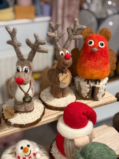 Three handmade holiday decorations: two reindeer and a vibrant orange bear.