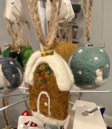 Decorative felt ornaments, including a gingerbread house and a snowman on a blue ball.