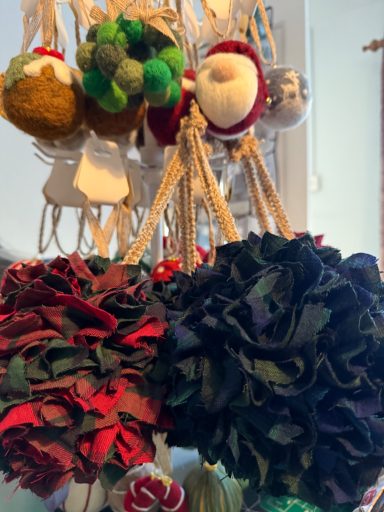 Colourful handmade decorations in various shapes and textures hanging on display.