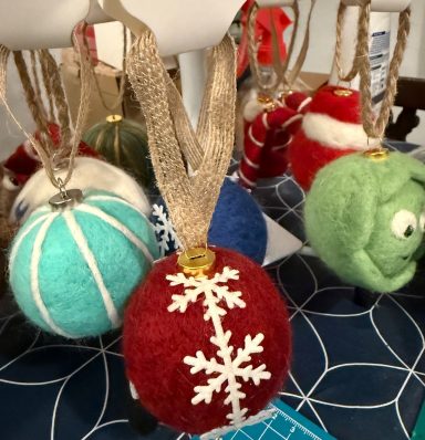 Colourful handmade Christmas ornaments with various designs, including snowflakes and characters.
